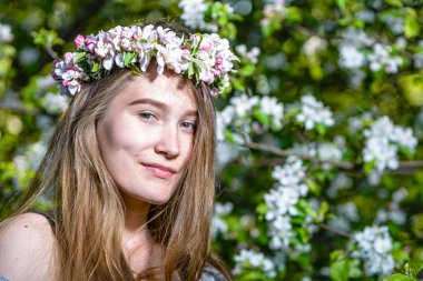 Bir çelenk elma ağacının çiçekli güzel genç kadın. Bahar bahçe içinde bir kız portresi yüz.