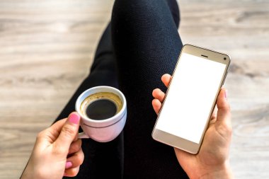 Kişi ile akıllı telefon elinde kahve sırada, beyaz perde ve boş kopya alanı, rahatlatıcı veya evde çalışma için Internet kullanan kişiler ile smartphone