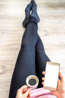 Cep telefonu ve kahve ile kişi. Beyaz modern smartphone ekran ile tutan el. Ana sayfa veya çevrimiçi alışveriş, yaşam kavramı çalışmak için Internet kullanan kişiler