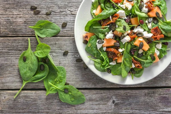 Verse Fruit Salade Met Spinazie Bladeren Bovenaanzicht Plaat Houten Tafel — Stockfoto