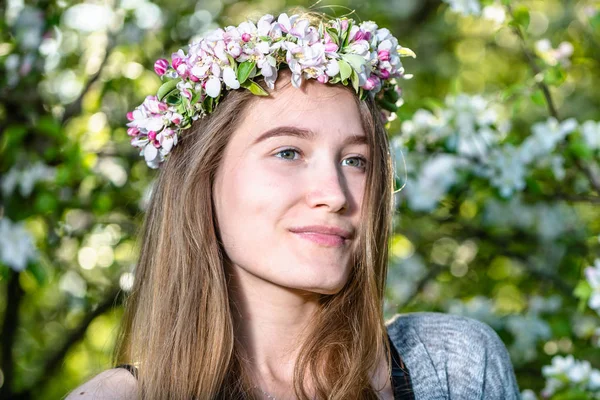 Beautiful woman face skin, portrait outdoor. Girl in spring floral wreath on a head.