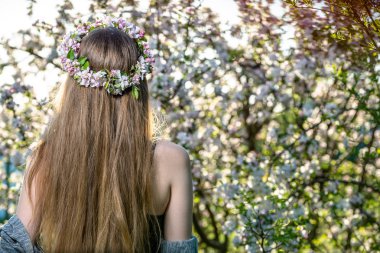 Bahar çiçeği bahçe ile çelenk içinde uzun saçlı kadını arkadan görünüm