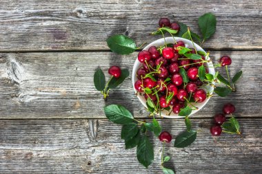 Taze kiraz bir kase. Ahşap masa, düz yatıyordu kırmızı tatlı kiraz meyve görünümü top.