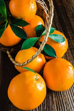 Taze turuncu meyve hasat. Ahşap arka planda bir sepet içinde organik turuncu.