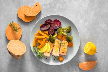 Pişmiş sebze ve pişmiş somon ile gurme gıda. Tabak üzerinde akşam yemeği, üst görünüm