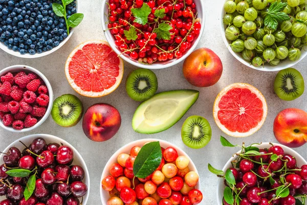 Comida saludable en la mesa. Desayuno en tazones con superalimentos orgánicos frescos, dieta vegana con surtido de frutas y bayas, puesta plana, vista superior . —  Fotos de Stock