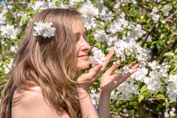 Hermosa mujer entre flores de primavera en el jardín — Foto de Stock