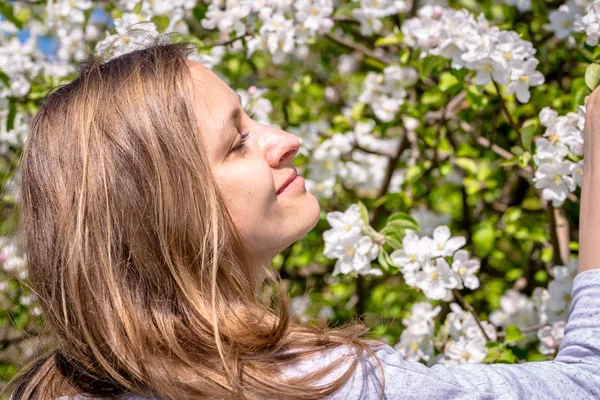 Piękna kobieta wśród wiosennych kwiatów w ogrodzie — Zdjęcie stockowe