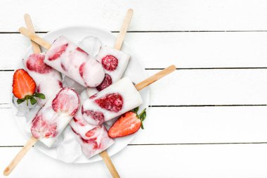 Çilek ile ev yapımı Popsicles, süt ve dondurulmuş meyveler ile dondurma