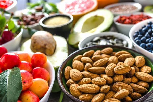 Bowl with almonds and other superfoods on table. Breakfast containing healthy food, organic vegetarian nutrition like nuts and fruits — Stock Photo, Image