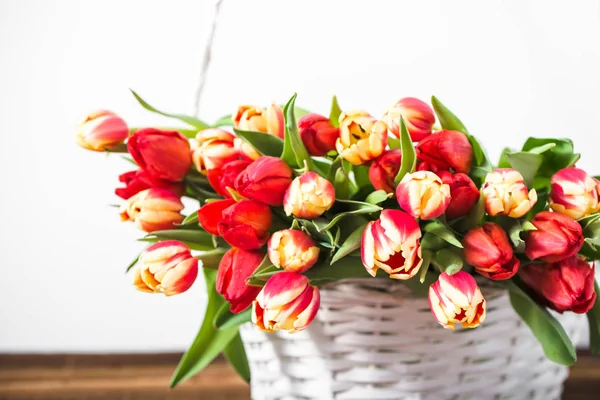 Arrière-plan avec bouquet de tulipes dans un panier. Concept cadeau fête des mères . — Photo