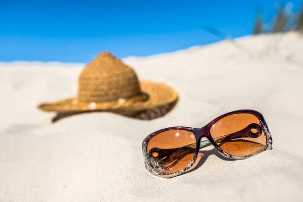 Sombrero y gafas de sol sobre arena. Accesorios de playa, vacaciones de verano, Mar Báltico, Polonia —  Fotos de Stock