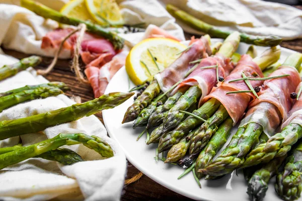 Espargos assados verdes com carne. Aperitivo na placa . — Fotografia de Stock