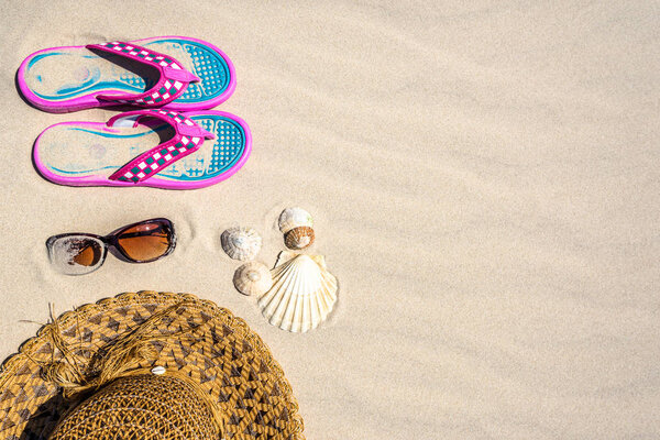 Summer background with vacation accessories on the beach, top view on sand