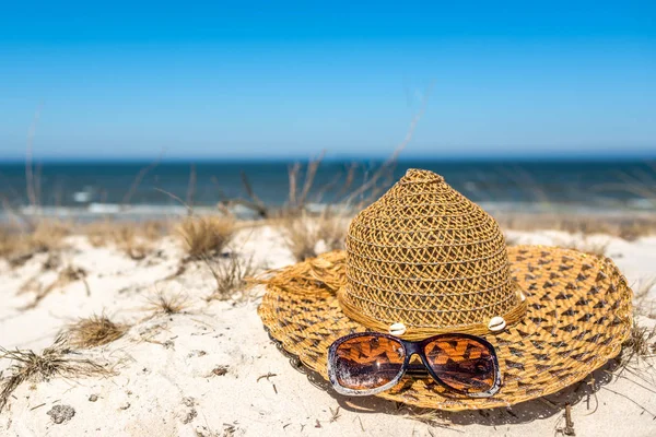 Playa de arena azul y blanca con sombrero y gafas de sol, paisaje de vacaciones de verano. —  Fotos de Stock