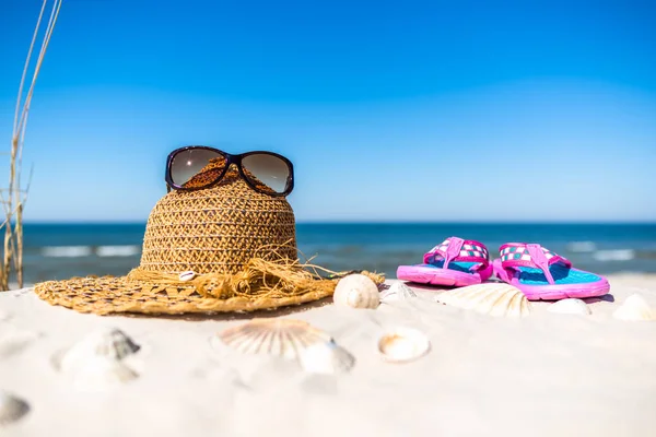 Bakgrund med semester tillbehör på stranden - solglasögon hatt och flip flop på sand. Sommar semester banner. — Stockfoto