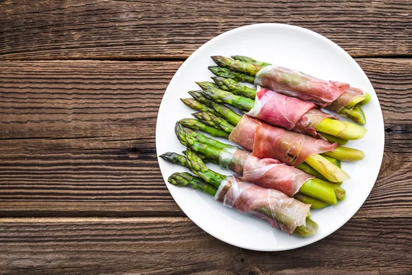 Espárragos cocidos. Aperitivo con verduras y carne, plato italiano en plato . — Foto de Stock