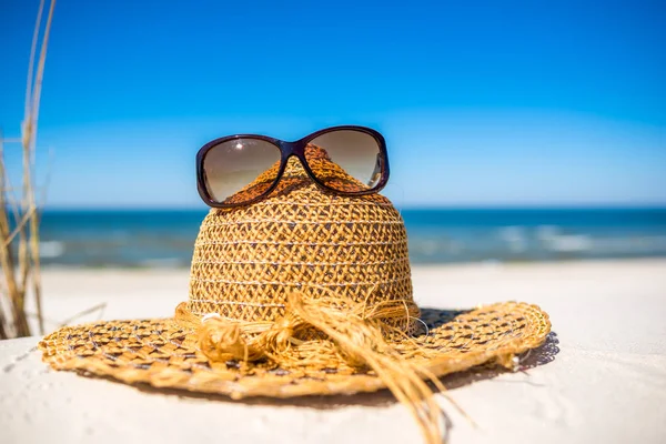 Accesorios de playa de verano sombrero de sol y gafas de sol en la arena. Fondo de vacaciones de verano, Mar Báltico, Polonia . —  Fotos de Stock