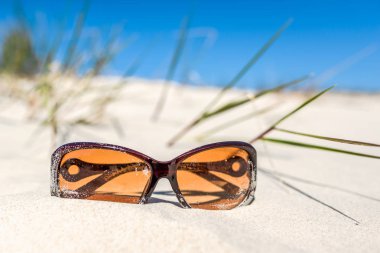 Mavi gökyüzü, kum plaj ve güneş gözlüğü, yaz tatili arka plan