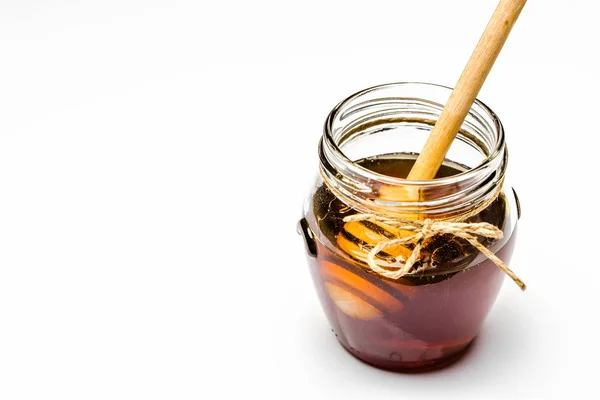 Pot et bâton de miel foncé dans du miel isolé sur fond blanc — Photo