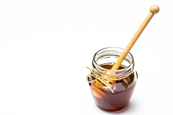 Verre pot de miel et trempette dans le miel sur fond blanc — Photo