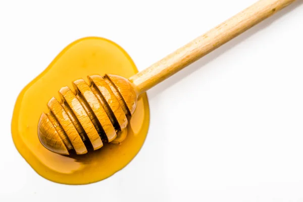 白い背景に隔離された蜂蜜の黄色の滴の蜂蜜ディッパー — ストック写真