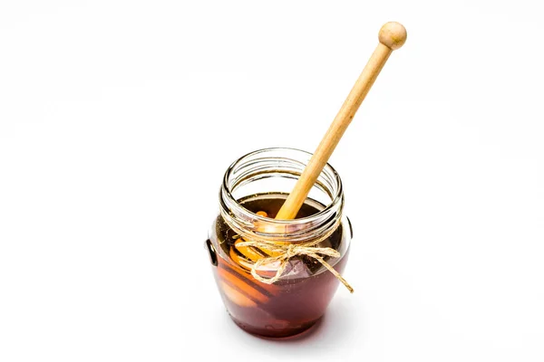 Pot en verre de miel et trempette dans du miel brun isolé sur fond blanc — Photo
