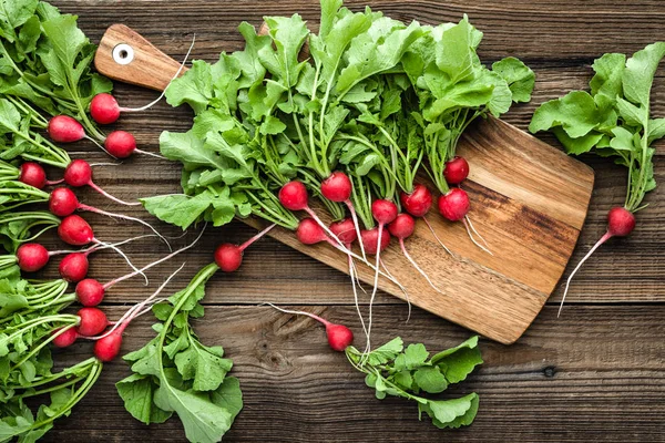 Bio organiczne warzywa. Gospodarstwo świeże rzodkiewki, czerwone rzodkiewki ogrodowe na drewnianym tle. — Zdjęcie stockowe