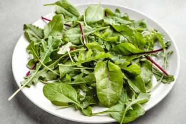 Tabakta taze yeşil salata karışımı. Pancar, arugula ve ıspanak yaprakları. Sağlıklı gıda, vegan diyet kavramı.