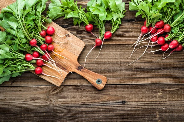 Gospodarstwo świeże warzywa organiczne. Świeżo pozyskane rzodkiewki, czerwona pęczek rzu na drewnianym stole. — Zdjęcie stockowe