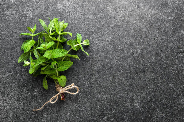 Freshly harvested herbs from the garden. Fresh mint leaves or peppermint. Bunch of mint on black background.