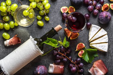 Yemek arkaplanı. Şarap ve abur cubur seti: taze meyve, peynir aperatifi ve şarap şişesi, üst manzara.