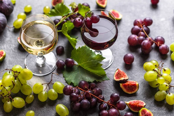 Uvas e vinhos variados, taças de vinho tinto e branco — Fotografia de Stock