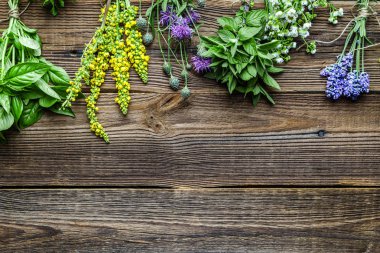 Ahşap arka planda bir demet taze bitki, üst manzara.