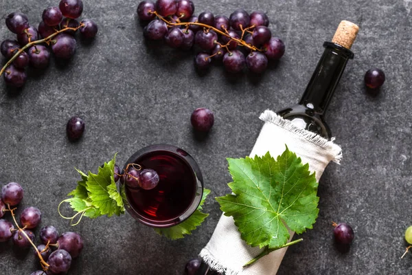Verre à vin rouge, fruits de raisin frais et bouteille de vin, vue de dessus — Photo