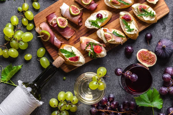 Buffet com lanche de vinho. Tapas tradicionais - mesa espanhola com comida ou aperitivo italiano: bruschetta com queijo e carne . — Fotografia de Stock