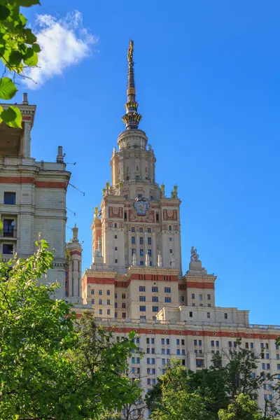 Binaların bir mavi gökyüzü ve yeşil ağaçlar arka plan Lomonosov Moskova Devlet Üniversitesi (MSÜ)