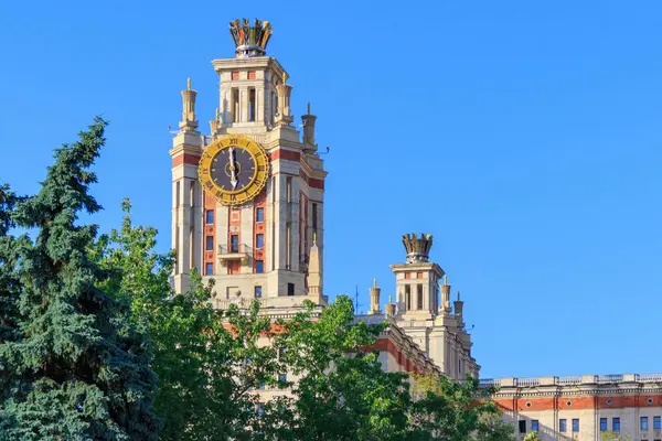 Lomonosov Moskova Devlet Üniversitesi (MSÜ) saatiyle karşı yeşil ağaçlar güneşli yaz akşamları kule.