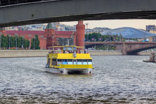 Moskova, Rusya - 19 Haziran 2018: köprünün altından bir bulutlu yaz akşamı Moskova Kremlin bir arka plan üzerinde Moskova Nehri üzerinde yüzen zevk tekne