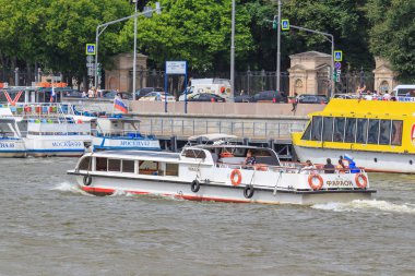 Moskova, Rusya - 21 Haziran 2018: Moskova Nehri'ne iskelede bir arka plan üzerinde güneşli yaz günü içinde yüzen küçük turistik tekne