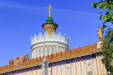 Moskova, Rusya - 01 Ağustos 2018: Çatı Pavyonu ile mavi gökyüzü ve yeşil ağaçlar üzerinde sergi başarıları, Ulusal Ekonomi (Fuar) Moskova'da karşı Sovyet yıldız ile yaldızlı spire Ukrayna SSC