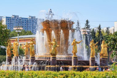 Moskova, Rusya - 01 Ağustos 2018: Çeşme dostluk SSCB Cumhuriyetleri üzerinde fuar Moskova'da bir mavi gökyüzü arka plan üzerinde güneşli yaz sabah simgeleyen yaldızlı bronz kızlarla halkların