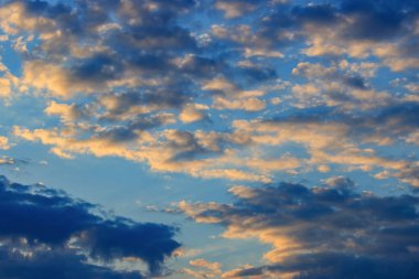 Yaz aylarında gün batımında turuncu bulutlar ile mavi gökyüzü