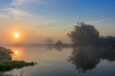 Turuncu güneş yaz sabahı siste yüzeyle Nehri üzerinde. Nehir manzara
