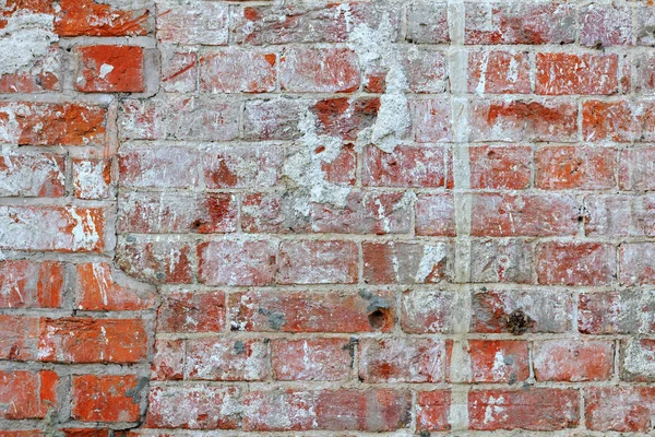 Vintage red brick wall texture with cement mortar and paint stains. Abstract brick wall background