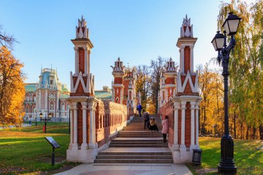 Moskova, Rusya - 17 Ekim 2018: güneşli sonbahar günü bir arka plan ağaç Tsaritsyno Park Moskova'da mavi gökyüzü karşı renkli yaprakları ile köprüde düşündüm