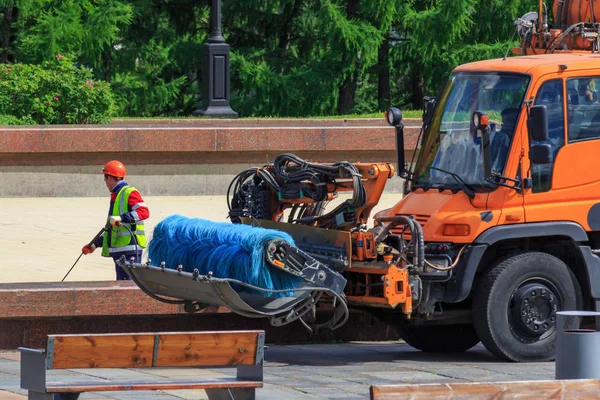 Moskva, Ryssland - 09 juni 2018: Arbetaren av städservice tvättar botten av fontänen i offentlig park på sommardag — Stockfoto