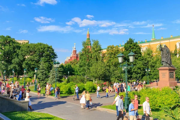 Moskva, Ryssland - 28 juni 2018: Turister promenad i Aleksandrovskiy Garden i Moskva på en bakgrund av byggnader av Kreml i solig sommarkväll — Stockfoto