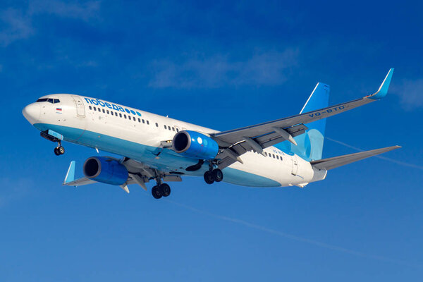Moscow, Russia - March 14, 2019: Aircraft Boeing 737-800 VQ-BTD of Pobeda Airine going to landing at Vnukovo airport in Moscow on a blue sky background at sunny morning