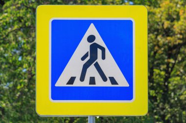 Güneşli yaz gününde yeşil ağaç çekim karşı yaya geçişi yol işareti